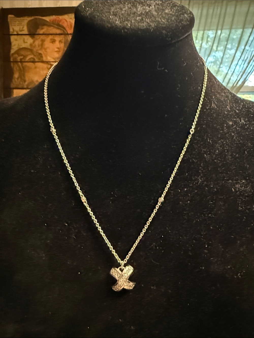 Gorgeous Kiss crisscross Silvertone pendant necklace with cubic zirconia station